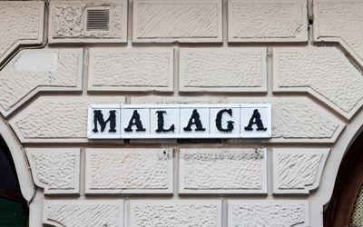 Tiled street sign on a stone wall reading Málaga, the location of the retreat.