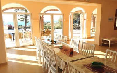 Light-flooded dining room in Villa Morisco with a long set table for shared meals during the retreat.